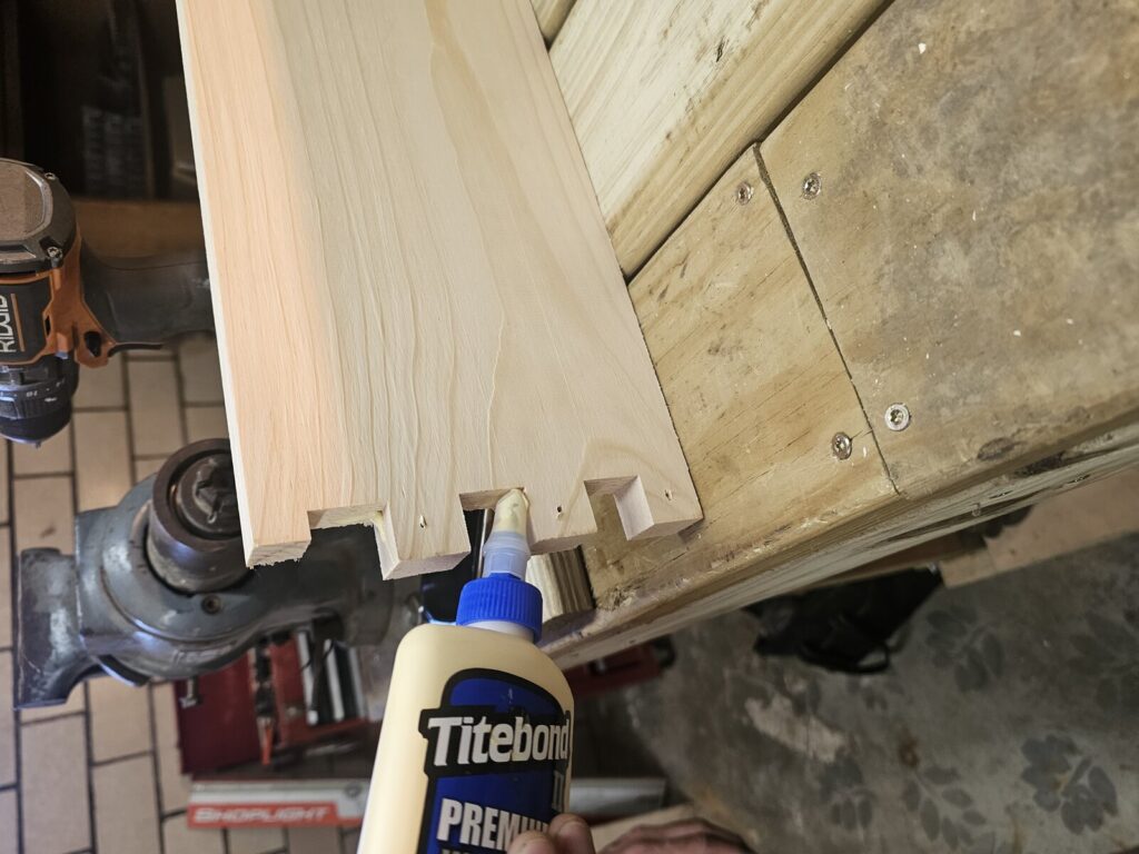 Hands gluing finger joints on hive body